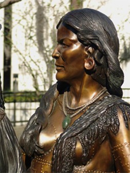 Photo with close up view of statue of Native American woman, part of bronze sculpture group "America Royalty"