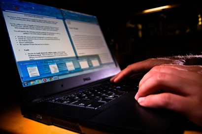 Photo of hands on a laptop keyboard.